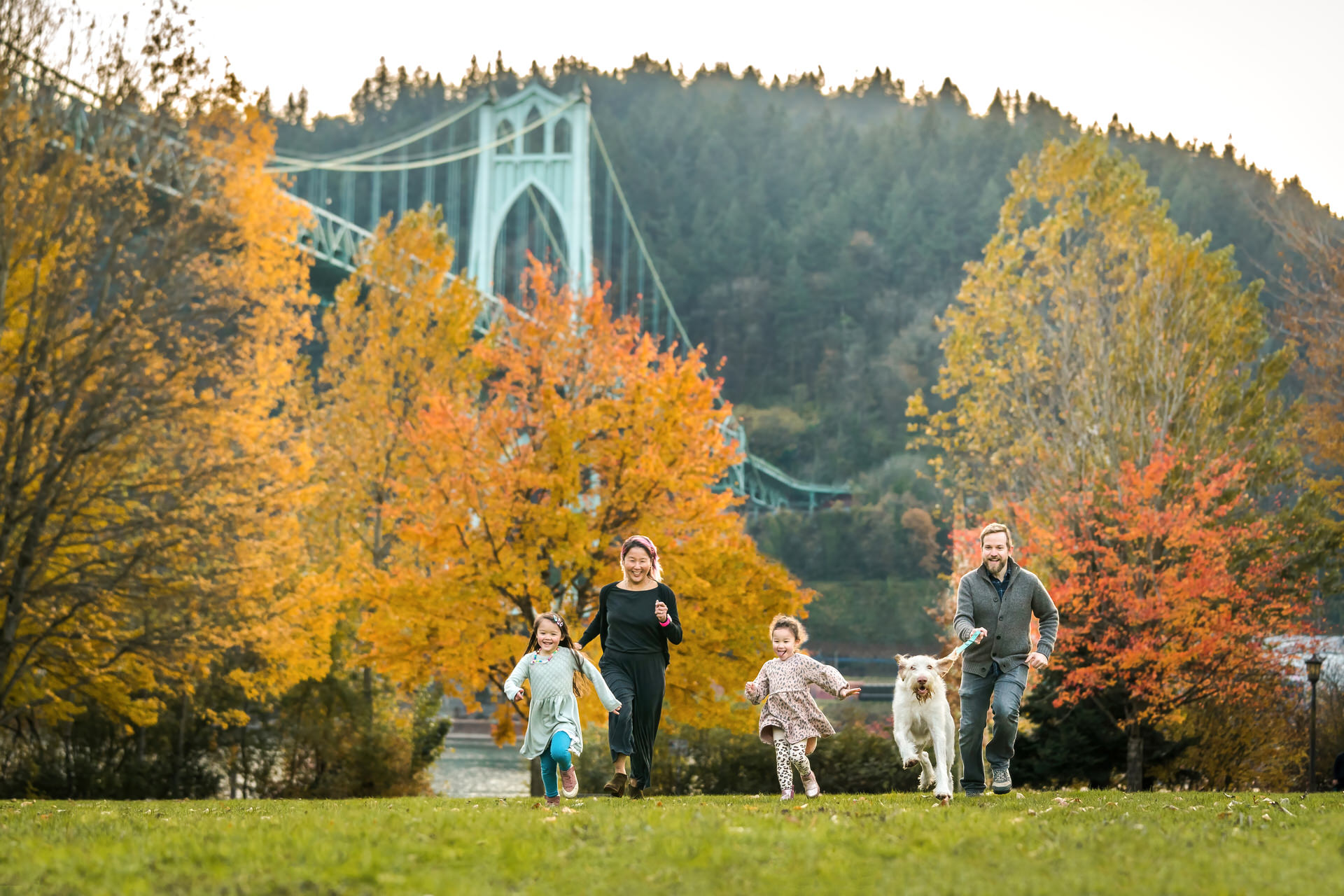 Family runs with Spinone Italiano dog at Cathedral Park in Portland, Oregon
