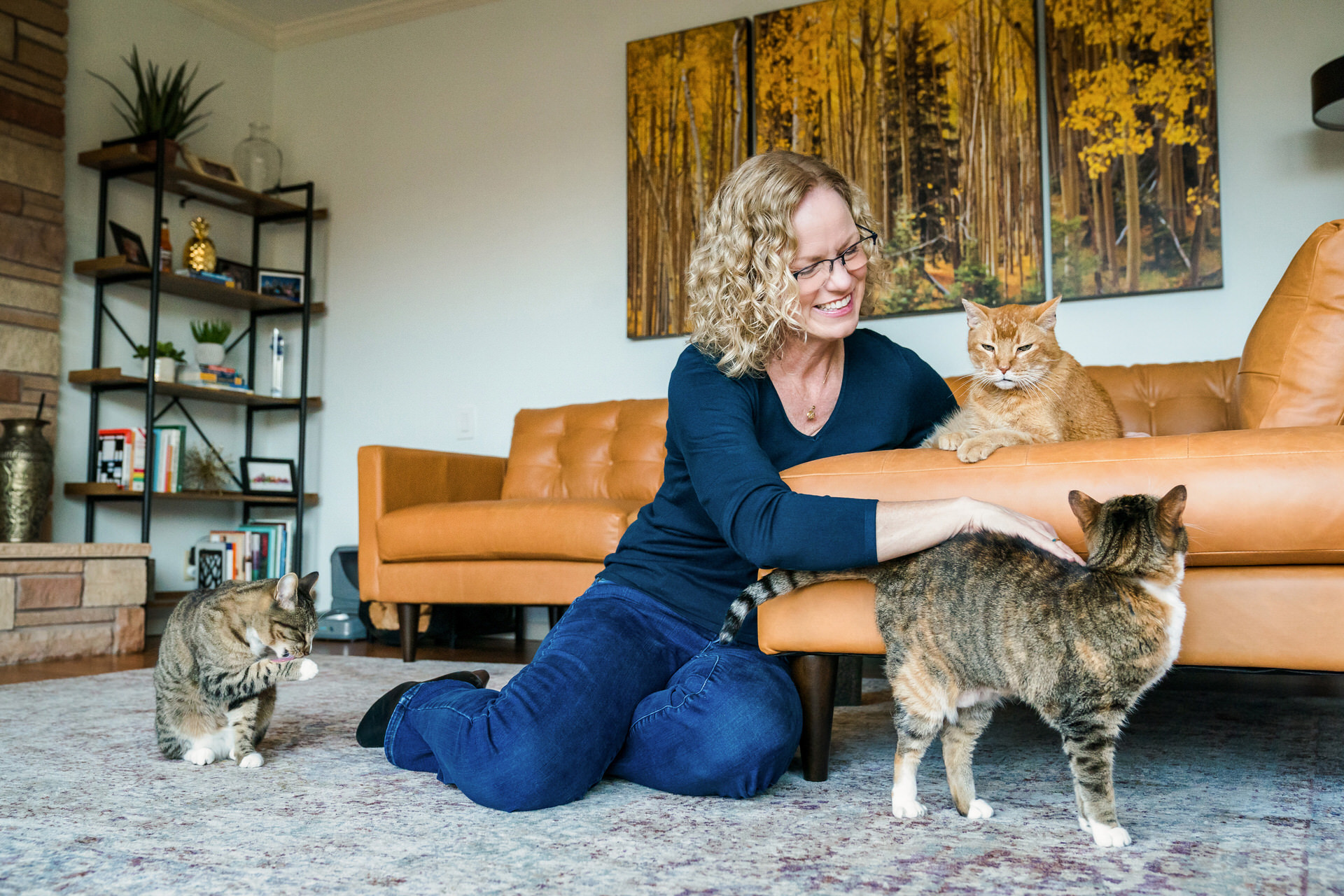 woman with blonde hair hangs out with her three cats